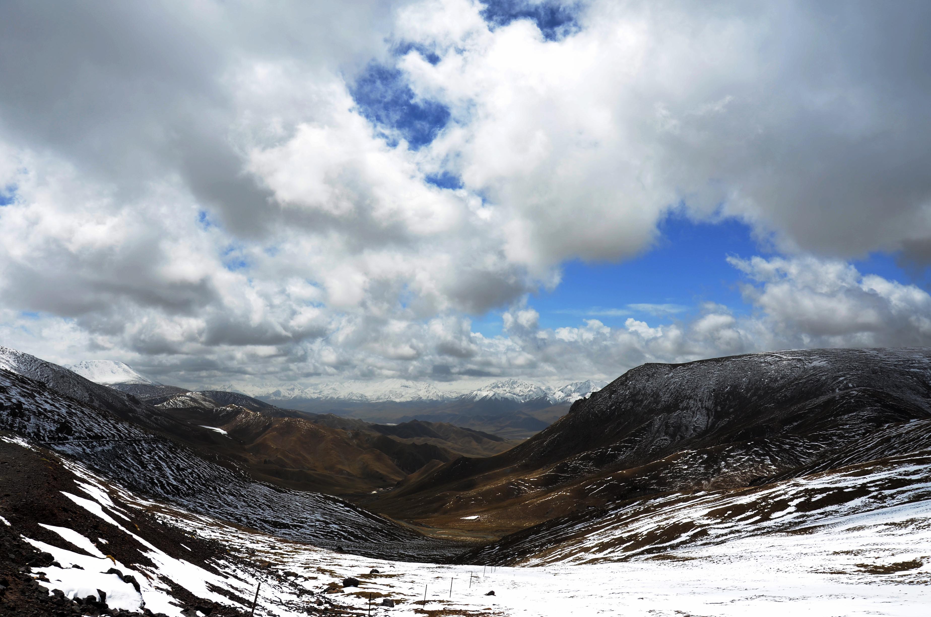 初入祁连山,两边出现积雪,远处已见雪山.